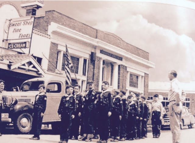 Boy Scouts parade in front of Sweet Shop and State Bank, undated