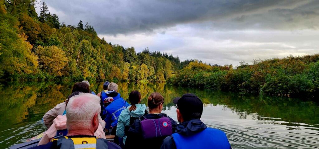 A group paddling the dragon boat along a scenic stretch of river.