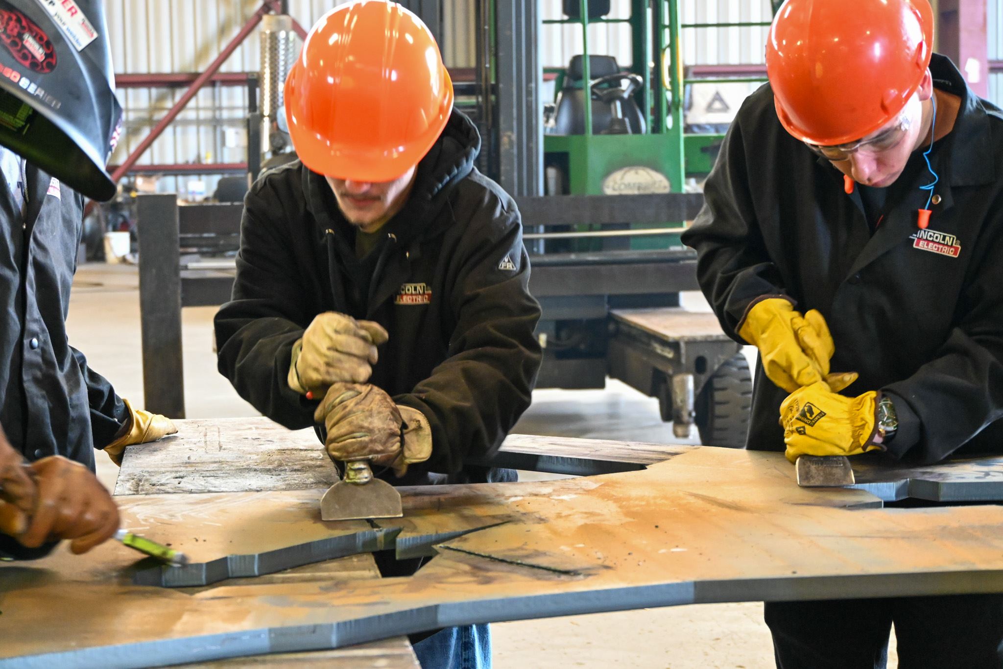 Students help clean the cut metal for the sculpture. 